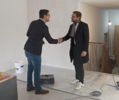 Un notaire salue un acheteur d'un bien immobilier à Bruxelles.